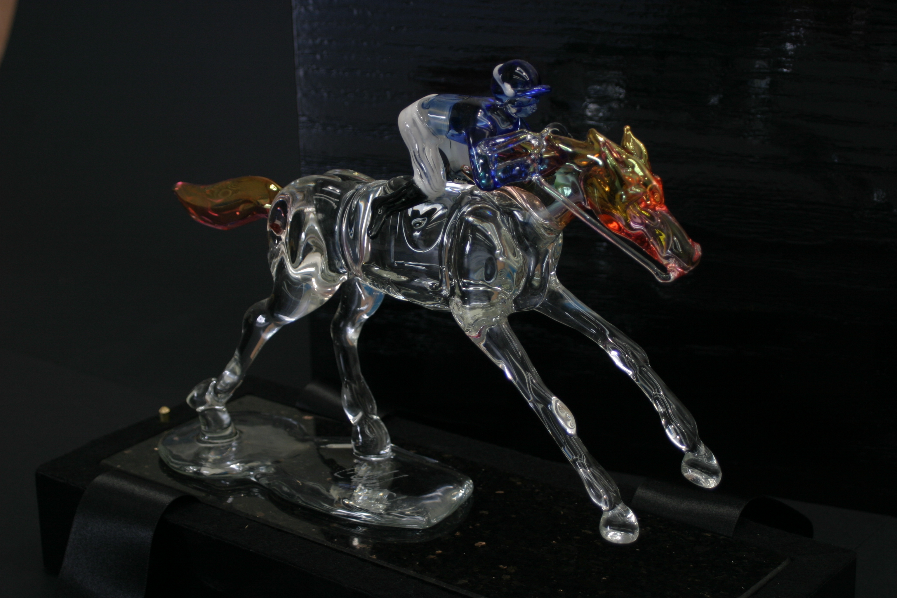 Close-up glass racehorse and jockey sculpture